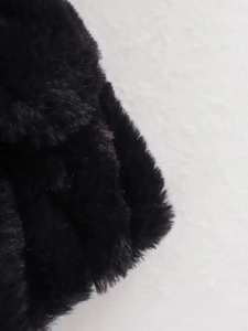 Close-up of thick black faux fur texture on a bomber jacket showing fiber details