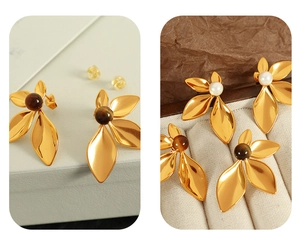 Detail view of 18K gold plated flower earrings with brown tiger eye stones and white pearls