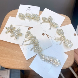 Close-up of alloy hair clips with rhinestones in leaf and butterfly shapes on display cards