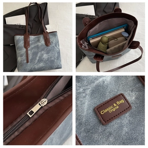 Detail view of denim blue tote bag featuring brown leather handles and spacious interior