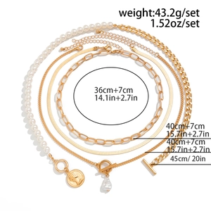 Detailed specs of four-piece gold necklace set with baroque pearls and coin pendant