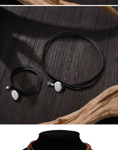 Detail of double-layer black cord necklace and bracelet with silver oval pendant and pearl