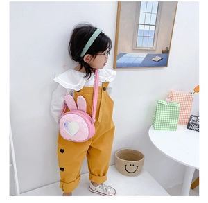 Close-up of pink sequin rabbit ear handbag with pearlescent heart on a young girl