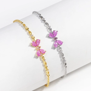 Minimalist gold and silver butterfly charm bracelets with pink zircon on white pedestals