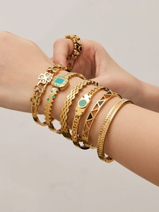 Detail of 18k gold plated bracelets set featuring malachite inlay and clover pattern