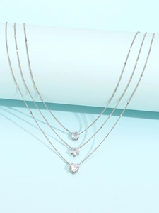 Detail of silver triple-layered necklace with teardrop, star, and heart zircon charms