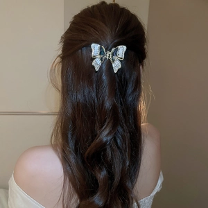 Elegante molletta per capelli a farfalla in zircone su lunghi capelli mossi castani