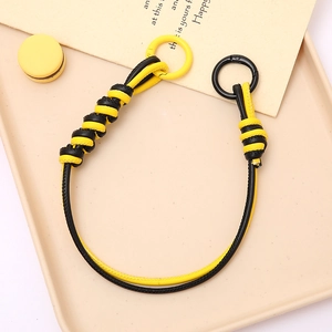 Detail of yellow and black braided PU leather phone strap with circular ring clasps
