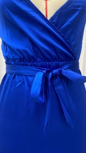 Detail of royal blue satin dress featuring a cinched waist and elegant bow tie-up design