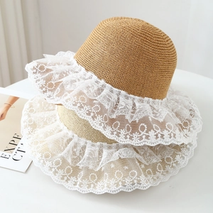 Close-up of woven straw hat texture featuring delicate white embroidered lace edging