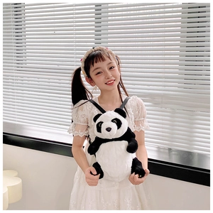 Detail of a large panda plush shoulder bag carried by a young girl in a white dress