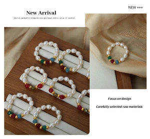 Detailed shot of handmade natural pearl beaded rings with colorful accents on silk