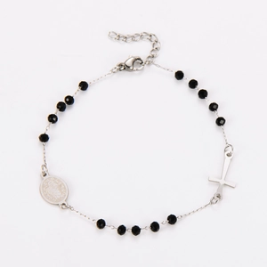 Detailed shot of black faceted beads and silver crucifix on a stainless steel bracelet