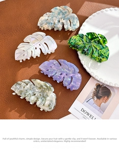 Macro shot of large acetate shark clips in elegant hollow leaf design with marble textures