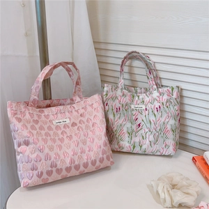 Detail of pink heart textured fabric tote and floral embroidery with simple wish label