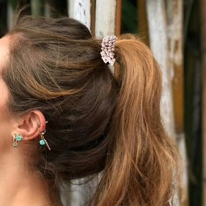 Detail of pink pearl beaded hair tie styling a ponytail with elegant turquoise earrings