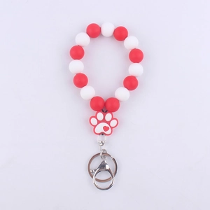 Detail of red and white silicone beaded wristlet with heart patterned dog paw pendant