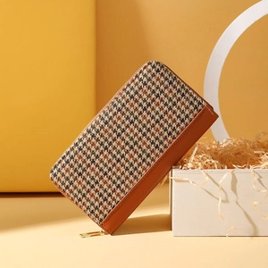 Détail du portefeuille long en toile avec motif pied-de-poule marron et zip doré