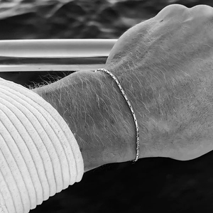 Vue macro d'un bracelet chaîne en acier titane élégant au poignet avec finition argentée