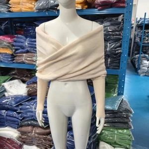 Dettaglio maglione in maglia beige con scollo a V incrociato e design versatile senza spalle