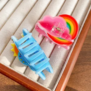 Cute weather acrylic hair claws with sun and rainbow patterns in a beige jewelry box