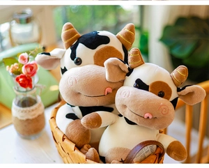 Primer plano de dos lindos peluches de vaca con manchas blancas y negras en una cesta