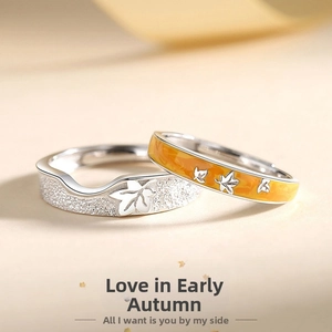 Detail of adjustable couple rings with maple leaf texture and orange enamel inlay