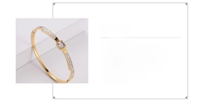 Macro detail of gold stainless steel bangle with square zircon and rhinestone accents