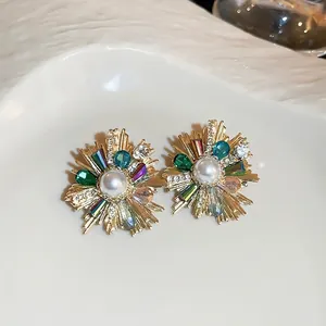 Vintage floral stud earrings with pearls and colorful crystals on a ceramic tray