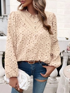 Detail of hollow embroidery on beige puff sleeve blouse with elegant stand collar style