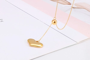 Macro shot of gold heart pendant and spherical bead necklace on open book pages