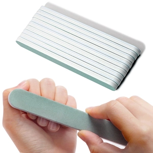 Close-up of green and white double-sided nail buffer files for polishing and shaping
