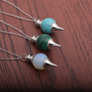 Three hexagonal stone pendulum necklaces in turquoise, green, and opal on wood