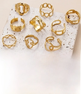Detail view of nine gold titanium steel rings with heart and geometric hollow designs