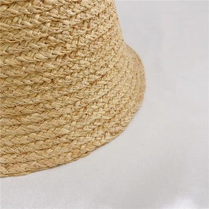 Macro shot of natural raffia weave detail on a beige bucket sun hat for women