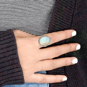 Close-up of a vintage oval moonstone ring with silver-tone setting on a model finger