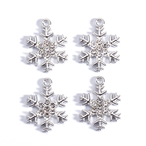 Detailed view of silver snowflake pendants with zircon stones and hanging loops
