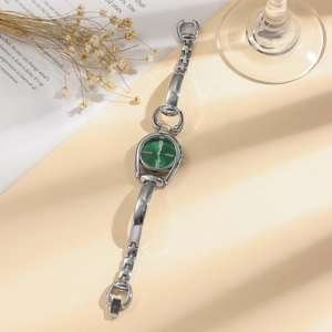 Detail of silver horsebit chain watch with green sunburst dial and Roman numerals