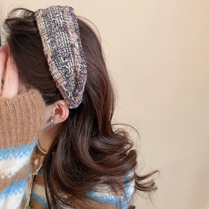 Close-up of wide multi-color tweed knit headband with elegant textured weave pattern