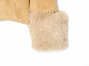 Détail du tissu en daim camel chaud et poignet en fausse fourrure sur une veste femme