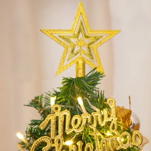Close-up of golden star tree topper with Merry Christmas sign and warm LED lights