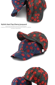 Detail view of cherry jacquard fabric on navy and black structured baseball caps