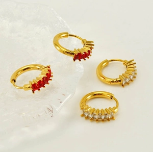 Détail de boucles d'oreilles créoles plaquées or 18K avec zircons rouges et blancs