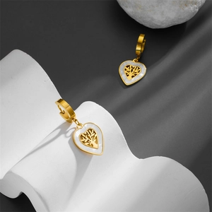 Vue détaillée des boucles d'oreilles cœur doré avec motif arbre de vie en nacre