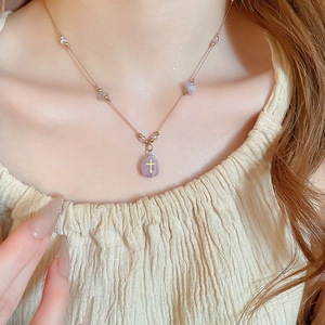 Détail du collier pendentif croix avec pierres brutes violettes sur un mannequin