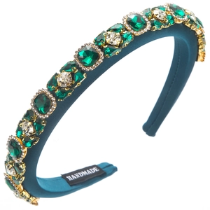 Detailed close-up of dark green velvet headband with hand-set emerald green crystals