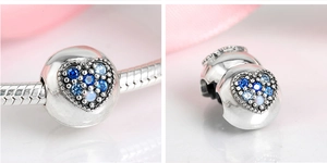 Macro detail of S925 sterling silver heart charm with blue and white stones on bracelet