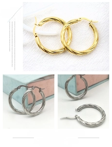 Detailed views of twisted hoop earrings in gold and silver finish with polished texture