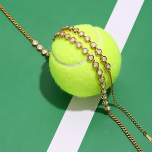 Golden cubic zirconia tennis bracelet on a green tennis ball with a sporty background