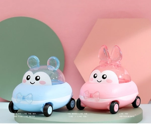 Detail of blue and pink cartoon toy car candy boxes on a green round base for baby gift